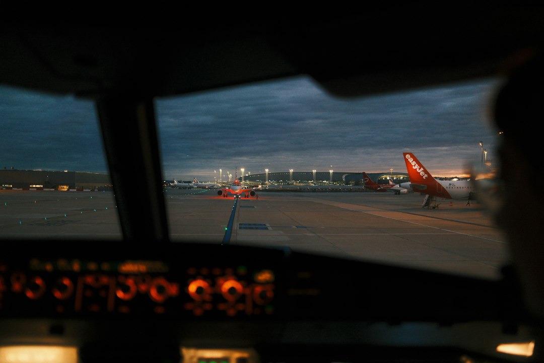 Blick aus einem Flugzeugcockpit auf ein Flughafenvorfeld bei schwachem Licht