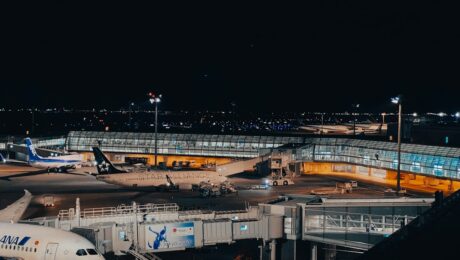Flughafen bei Nacht mit beleuchteten Terminalgebäuden und Flugzeugen am Vorfeld