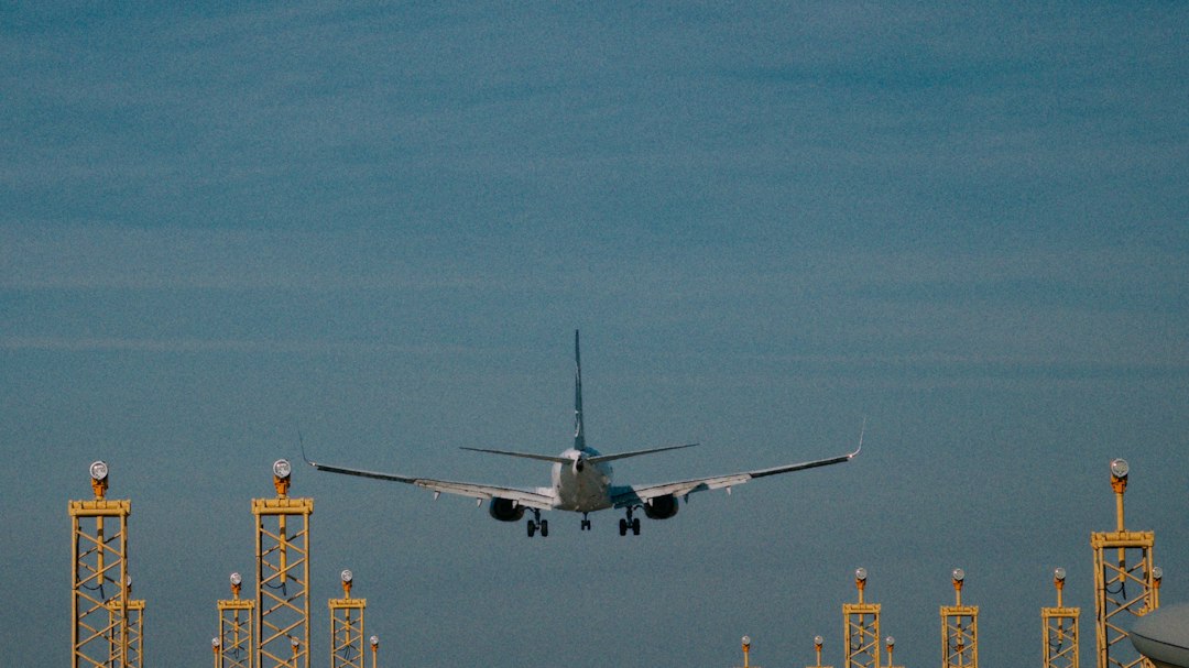 Verkehrsflugzeug im Anflug auf eine Landebahn über gelben Anflugbefeuerungs-Masten