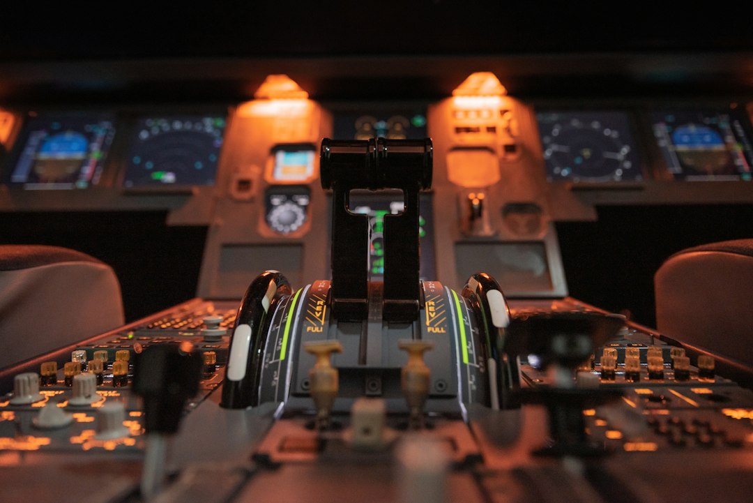 Schubhebel in einem Flugzeugcockpit, beleuchtet vom warmen orangefarbenen Licht der Instrumente
