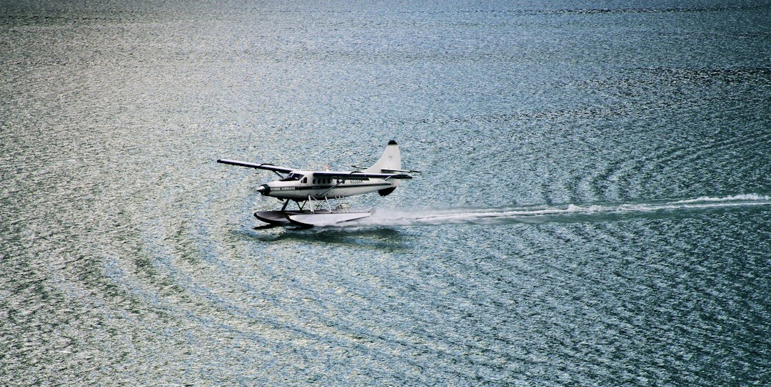 Weißes Wasserflugzeug liegt auf einer ruhigen Wasserfläche