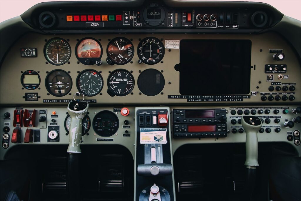 Graue und schwarze Bedienfelder mit Schaltern und Anzeigen in einem Flugzeugcockpit
