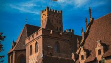 Die Backsteinburg Marienburg in Malbork, Polen, mit Turm und Flagge auf dem Dach
