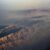 Luftaufnahme aus einem Flugzeug auf eine Gebirgskette mit Küste und Meer