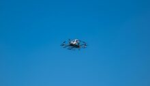 Kleines einmotoriges Propellerflugzeug im Flug vor wolkenlosem blauem Himmel