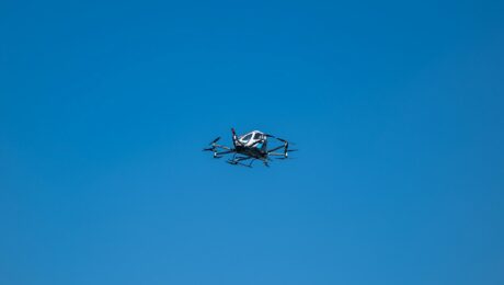 Kleines einmotoriges Propellerflugzeug im Flug vor wolkenlosem blauem Himmel