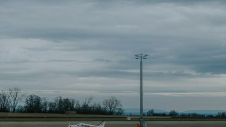 Kleines Propellerflugzeug auf einem Flugplatz unter bewölktem Himmel, aufgenommen in Erfurt