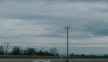 Kleines Propellerflugzeug auf einem Flugplatz unter bewölktem Himmel